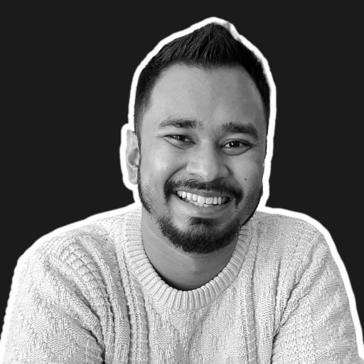 Mo Hassan, smiling, in a knit sweater
